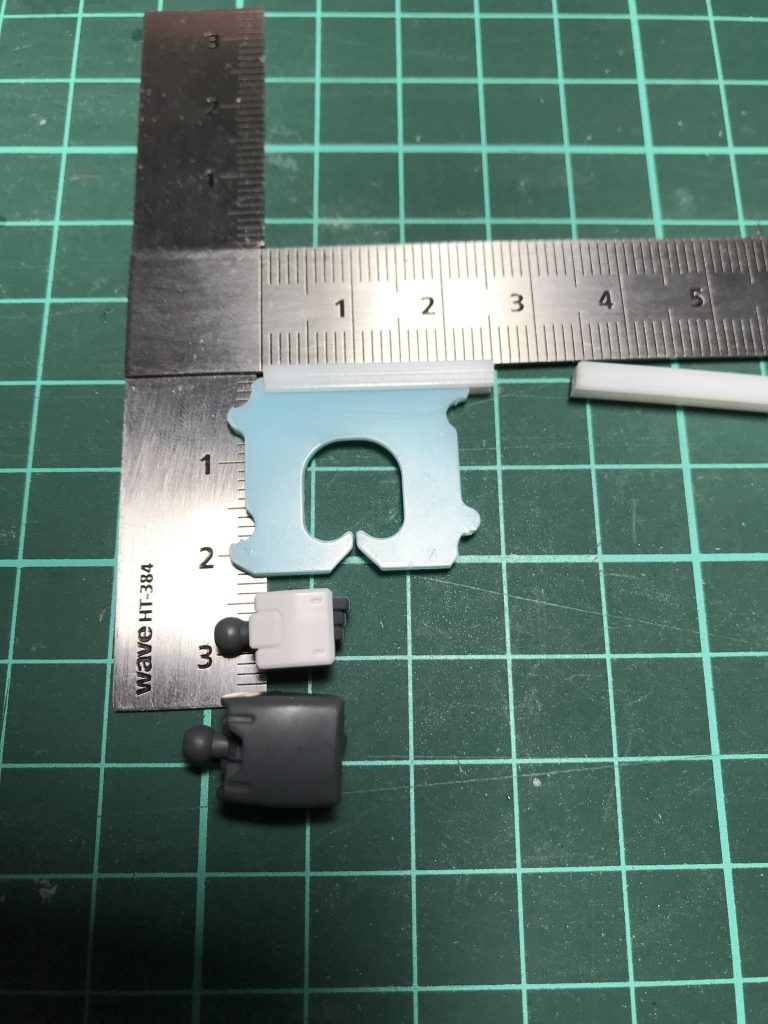 ## ③バッグクロージャーをコの字プラ棒に挟み、コの字プラ棒を切る。
挟んで銃身のサイズを決めるだけで接着は後でした方が良いと思います( ´ ▽ ` )
*ポイントはバッグクロージャーの挟み方とコの字プラ棒の長さです!*
写真の様に少しズラして挟んでやると、丁度バッグクロージャーの形が銃の撃鉄に見立てられるので超オススメです(≧∀≦)/!!
コの字プラ棒の長さはハンドガンだと*2.5ミリ*が丁度良いサイズでした。
宇宙世紀系の大きめの機体だと3ミリぐらいでもいいかも?
切り出す長さを変えるとライフルにも出来ますね( ^ω^ )