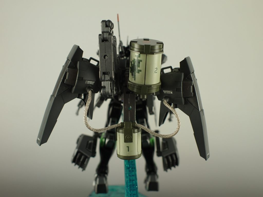 背後のライトニングMk2のブースターにはMSGのパーツ盛りをし、高出力ブースターを長時間使えるようなイメージでタミヤの銀色メッシュパイプで追加エネルギータンクと接続。
タンクは後付感を出したかったのでタンクのみミリタリーカラーにし、あえてプロペラントタンク状の細長い物ではないものを選びました。
MSGのフリースタイルガン付属のタンクを使用した「1」がブースター用で、上にある「2」のタンクは主武装のでっかい剣用です。
必殺技的な感じで、本気で殴りに行くときのみメッシュパイプで繋いでビーム刃を生成して使います。
「2」のタンク左のアームはシールド可動用のものです。両手はフリーにして、かつシールドを好きな方向へ向けられるギミック。
元々妄想戦記の戦車プラモに使おうと思っていたネタなんですが、我慢できず今回のガンプラにこのネタを使用。