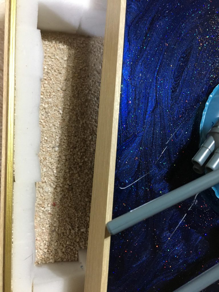 ちなみに……台座は、コンビニで買える一人前のおせちの箱を使っています。中には砂が入っています。
壁に砂が当たる時のパチパチ音を軽減させるため、スポンジを切って詰めています。