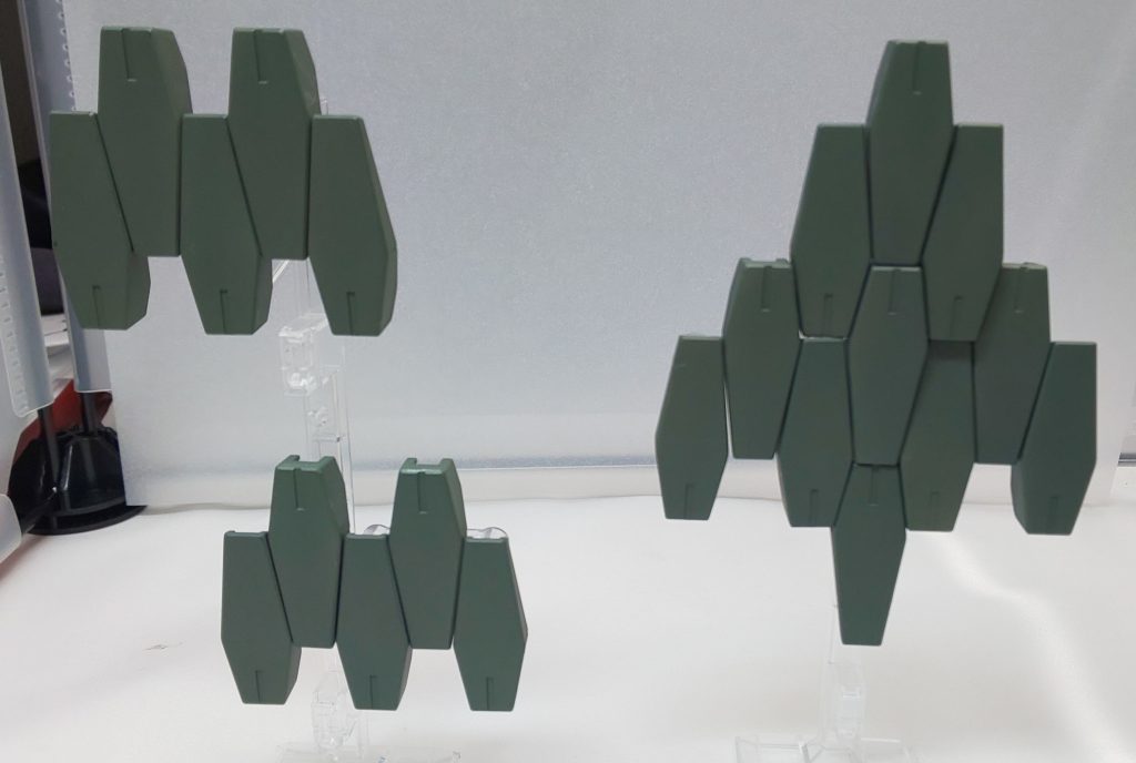 武装その2:GNシールドビットⅡ

ケルディムに装備されていたシールドビットからアサルトモードをオミットし、防御機能のみに特化させたもの。全23基搭載し、操作は緑ハロが行う。

カーボン強化とGN粒子の貯蔵量が増えたことで、改良前の1.5倍の防御力となった。非展開時はGNドライブから常にチャージされているため、かなりの長時間使用できる。
全方位の防御が出来る上に、シールドビットを5枚組み合わせるだけで、戦艦の主砲すらも防げるほどとなった。