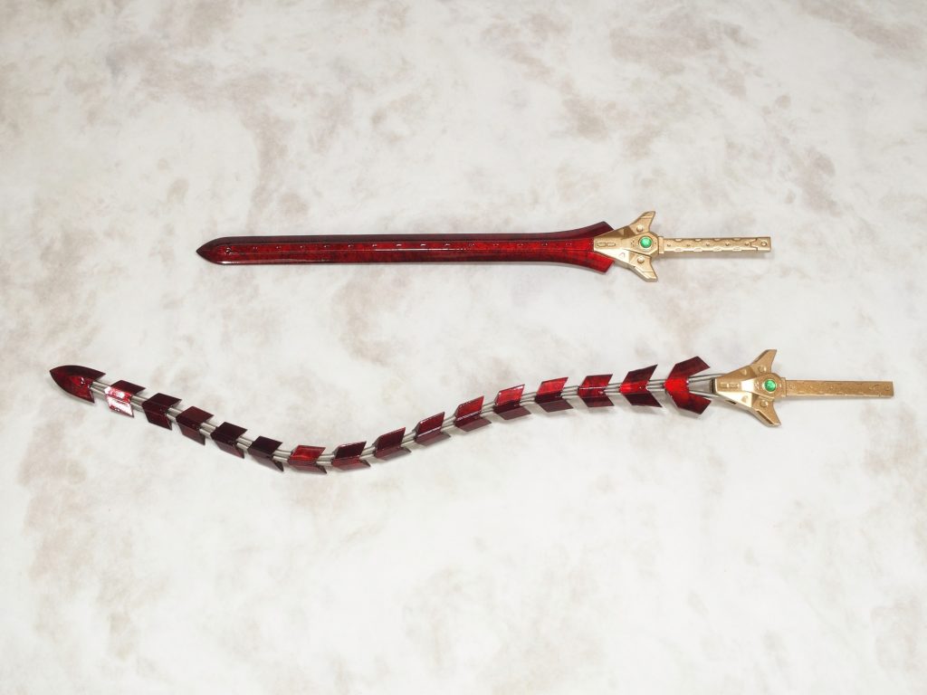 巨大なツヴァイヘンダー（両手剣）と尻尾のスタビライザー（放電器）は全く同一の一対のアイテムで、それぞれ両手剣、蛇腹剣、スタビライザーの3形態で使用可能。
機体名のヴリトラとは蛇の化生の事らしいので、もしかしたらこの剣こそが神機ヴリトラの本体かもしれない。
ブレードはヒヒイロカネとサイオニックメタル（精神感応金属）の合金らしく、強力なヒート剣として使用出来る他に、蛇腹形態では所有者が念じるだけで自由に動かすことが出来る。
蛇足だが、ツヴァイヘンダーと言っても神機のパワーをもって片手で振り回している。
レオンハルトはわりと正統派の騎士なので蛇腹剣は基本的に使わない。
　
　
　
ツヴァイヘンダー&蛇腹剣はコトブキヤM.S.G.ビーストマスターソードです。
キットそのままではワイヤー表現が安っぽいのでちょっと改良。