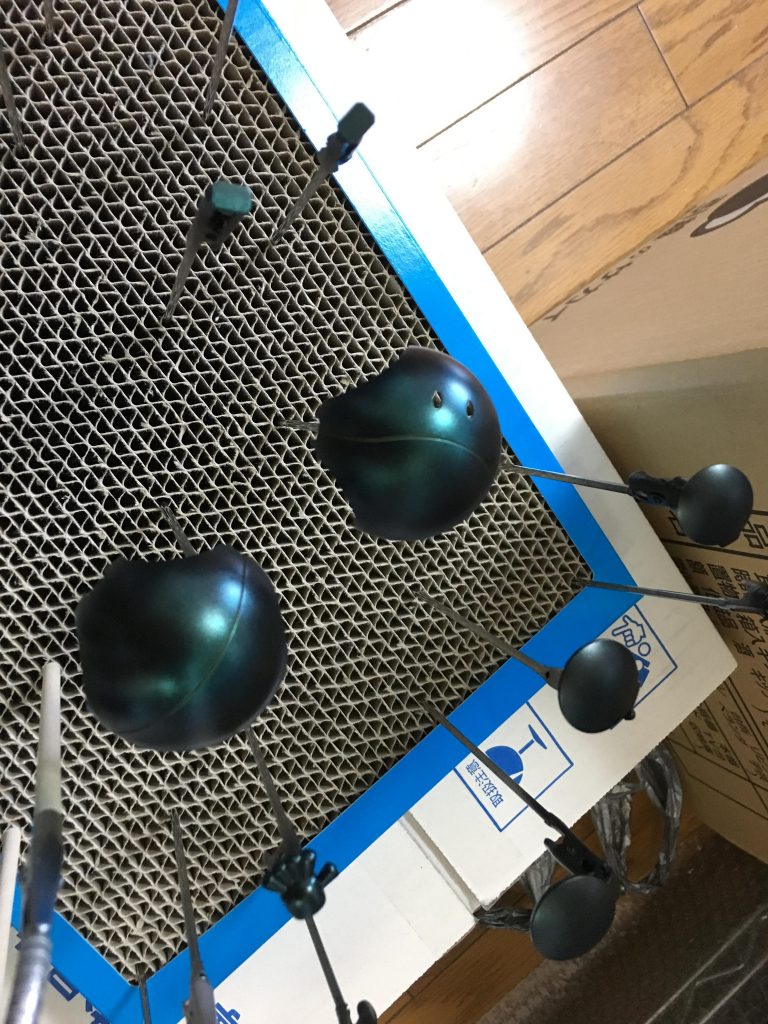 下地に黒のサーフェイサーを吹いてから、パール塗装1回目の画像。ほんのり緑の粒子が乗っかった感じ。