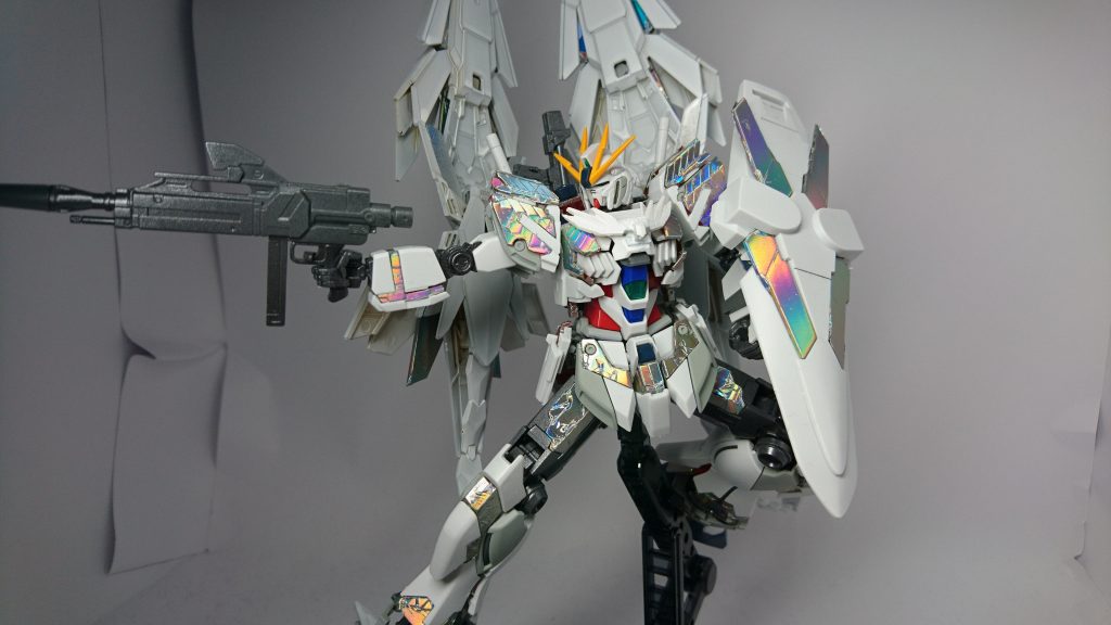 サイコフレームの発光色は赤や青ではなく「虹色」 これが共振によるものなのか、それとも改良によってこのように発光するかは不明。
ガンプラバトルにおいては、プラフスキー粒子を戦闘中にチャージしており、リミッターである「NT-D」を発動することで解放。RGシステムとは違い、フレームではなく、表面のサイコフレームからの出力アップを行うため、機体へのダメージが少なく、上手く行えば複数回使用可能。 しかし、使用後は粒子不足によるパワーダウンが発生する。