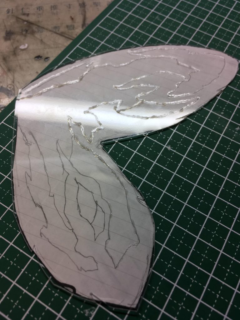 模様を描いた型紙をベースに切り出し、ジェルメディウムで模様をなぞります。