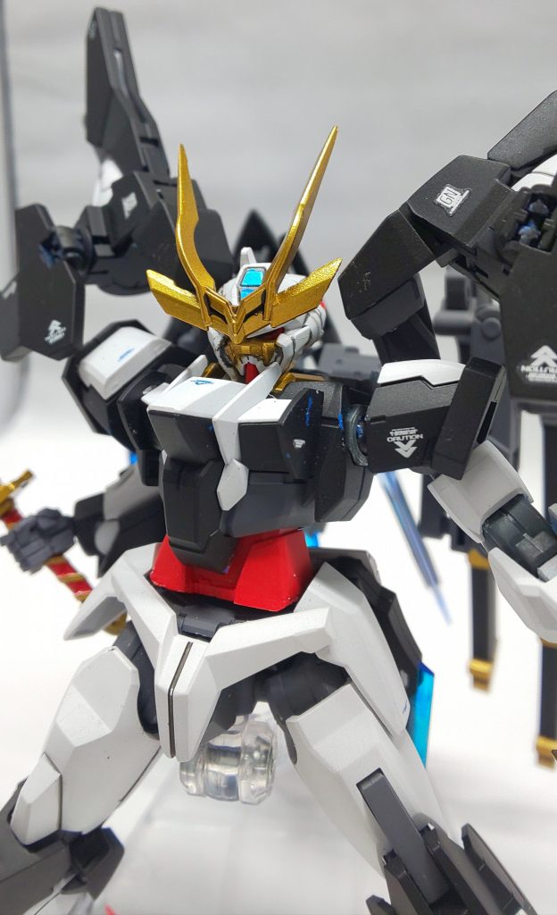 カラーリングですが、歴代のグラハムさんの愛機に則って、黒を基調としました。自分の中のグラハムカラーは黒なので。更にガンダムらしい白を取り入れ、歴戦の武士らしく仕上げたかったので、まあ、それなりの表情にしてみたつもりです。戦国アストレイのヘッドが、まあイメージに近かったので拝借しました。
そのままでは首が埋もれすぎて上下左右に動かせなかったので、2mm延長しました。胴体も、全体のバランスを見て2mm延長してます。
今回も、マスキングが結構しんどかったのですが、ロックオンガンダムに比べるとパーツ総数が圧倒的に少なかったので、楽しく製作出来ました。
刀の刃は、フラットブラックの上に直接スターブライトシルバーを吹き付けたので、見る角度によって刀身が黒メタリックぽく見えます。
ゴールドも、3色を重ね吹きして、つや消しと光沢を使い分けてみました。
塗装がすり減るのが嫌だったので、パーツのすりあわせは今回特に気を付けました。
クリアパーツも、地味にパール吹いてるんですが、写真だと全然わかんないですね(泣)