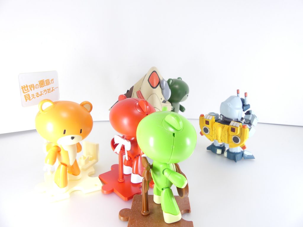 第39改「GBNLives:GBNとプチッガイ」アッガイ?くま?いやいや、プチッガイ。プチッガイ。ベアッガイIIを小さくした、通称「かわいいガンプラ」・・・というのはさておき。あ、ベアッガイIII(さん)じゃないからね。ベアッガイの改良型、ベアッガイIIだから・・・もともとは、「ガンダムビルドファイターズトライ」でコウサカ・ユウマが作った(設定)「ベアッガイF(ファミリー)」の背中ユニットだったもの。本体になっている白いベアッガイII・・・通称・ママッガイとはチェアーストライカー(椅子)で繋がっていて、各種バックパックのブースターユニットと同じ役目を果たすわ。要は、独立してのサポートや本体撃墜時の代替ユニットとしてね。「BFT」の作中ではママッガイが撃墜された後縦横無尽の活躍を行い・・・黒いターンエーガンダムに「夏の恐怖体験」をかましてやったっけ。・・・と、ここからがプチッガイの本領だったのよねと、カツラギも当時を振り返っているわ。GPデュエルの販促番組として放送された「BFT」の放送終了後、このユニットだけ単体で欲しいってガンプラビルダーが急増。ついに単独販売を成し遂げたの。その後のビルドシリーズ作中でも「普通に販売されている」設定になって、アイラ・・・もとい謎の少女も初ガンプラに選んだのはこれだったわ(「ガンダムビルドファイターズトライ アイランド・ウォーズ」)。シリーズはカラーバリエーションはもとより、武器ならぬ小物持ちやキャラに扮した「きゃらっがい」、「ガンダム00」とのコラボ企画や限定品まで・・・相当長く続けられることになったのよね・・・想定を遙かに超えたヒット商品となったプチッガイを、GBN世界でも活かさない手はないわけで。イベントの一つとして「フェス」って言うのがあってね。特定のガンプラに焦点を当てて、バトルのみならずみんなで楽しみましょう、って言うんだけれど・・・早くからその題材として選ばれたのが、このプチッガイやベアッガイ。「かわいい」は正義。・・・かどうかは置いておいて。ガンプラに触れることの少なかった女性や初心者が気軽に楽しめるガンプラって事で、今後も活躍してくでしょ。ところで・・・アッガイ要素は、って?確かに、元機体はアッガイよ。ほら、水中では地上よりも早く動けるし。