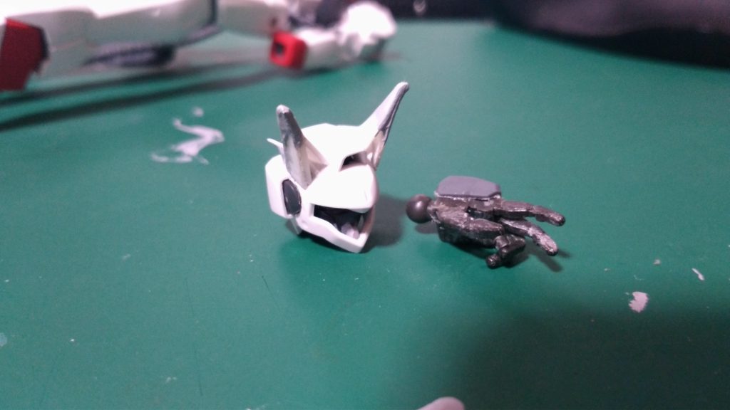 頭部はプラ板とパテでライオン耳を製造。
シアクアンタの耳のイメージでありつつ、
もっと大きめで尖ったデザインに。
弓をつがう手は連邦系平手パーツを加工して製造。
指の関節をカッターで切り欠いて、
任意の位置でプラ片を関節の隙間に戻して接着剤を流し込んで指の形状を変えています。
こういう細いとこでも強力に溶かしくっつけてくれるので、SPセメントはめちゃくちゃ役に立ちます。