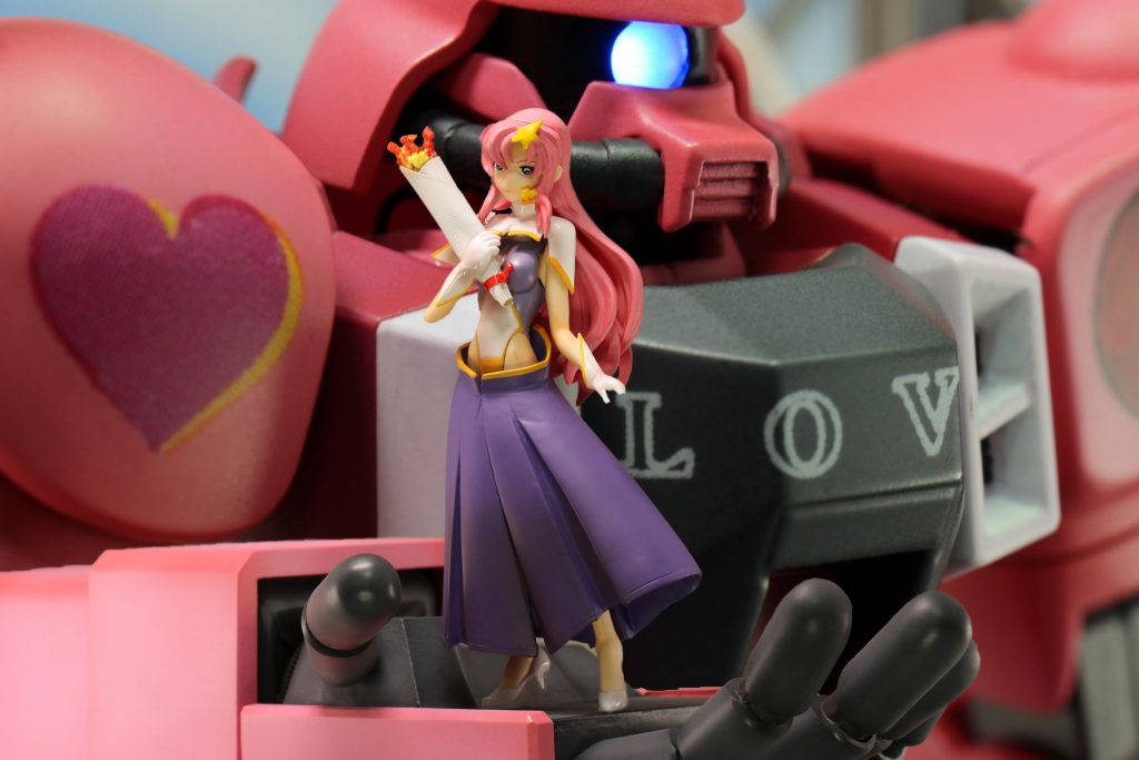 HGザクウォーリアを使ってガンダムSEED Destinyで印象に残っているシーンを再現しました。
PHASE_19「見えない真実」で、ディオキアのザフト基地で行われたラクス・クライン（ミーア）の慰問コンサートのワンシーンです。最初はHGザクウォーリアに合わせた1/144ミーアを製作しようとしましたが、細かすぎて断念。1/12ミーアフィギュアに合わせた1/12ザクウォーリアの右手を制作することにしました。