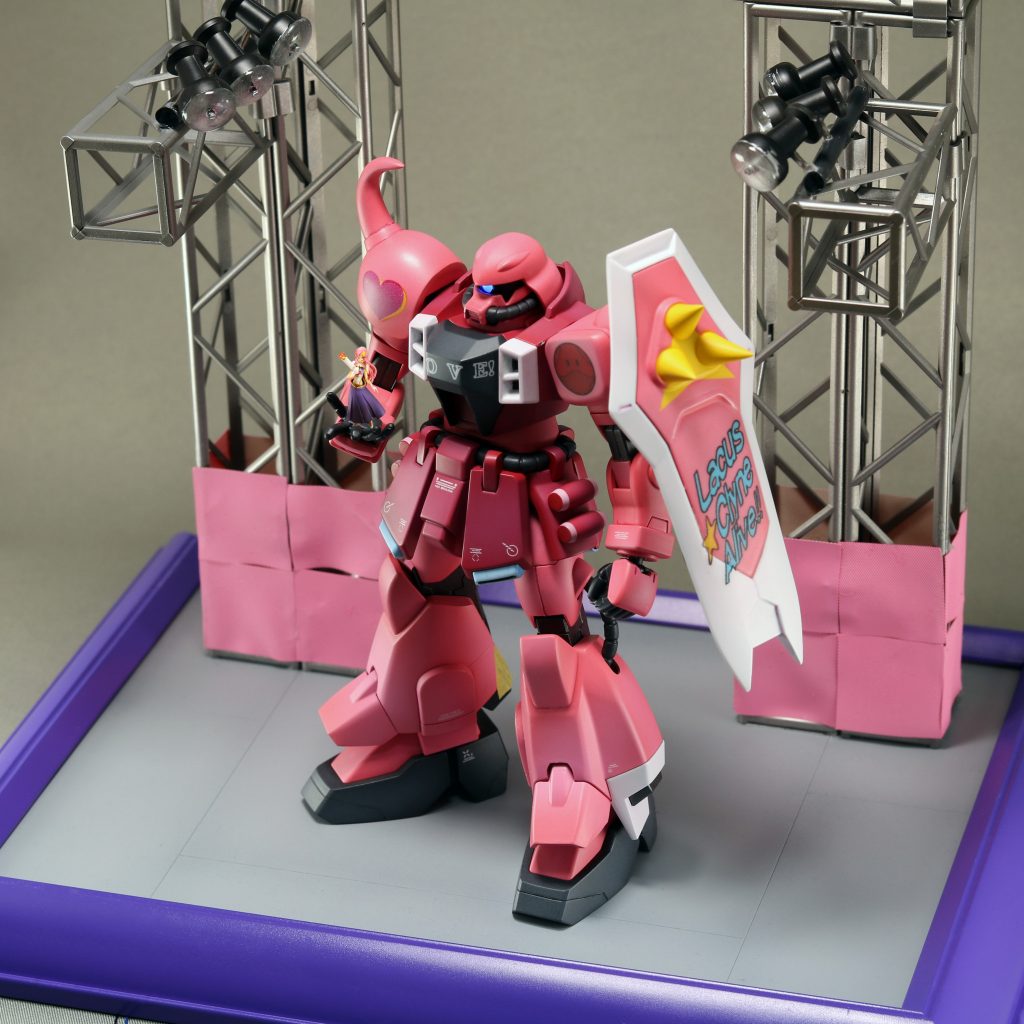 台座はコンサート会場をイメージして制作しました。トラス部分はMODELING SUPPLYシリーズのトラスを組み立てたもの、ピンクの部分は非粘着テープを切ったもの、照明は針を切った画鋲にクリアレジンを盛ったもの、地面は100均のプラ板とダンボールを使用しました。