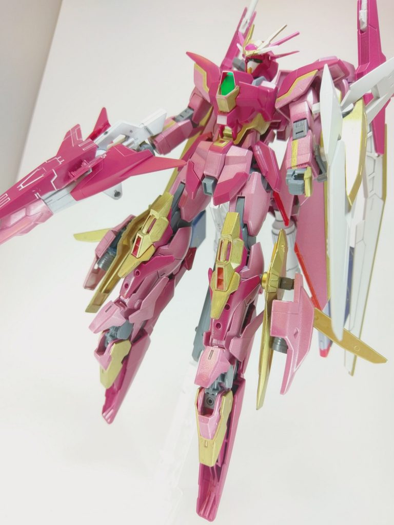 高機動モード。足裏のスラスターカバーと翼を展開することで高機動を実現する。本機体はインパルスガンダムアルクエクラ以上の機動性能を誇り、射撃、格闘能力と共に万能な仕上がりになっている。ＧＮドライブを2機搭載しているので通常エネルギーだけでなくＧＮ粒子を用いることが可能である。併用することで長時間の戦闘が可能になる。トランザムの使用も可能である。

塗装としては全塗装ではないもののだいたい塗装しました(初めての本格塗装)。若干のムラがあるのは許してください。缶スプレーとガンダムマーカーによる塗装になります。赤い部分はシャアレッド、ピンク色はパールライトレッド、ゴールドは全てガンダムマーカーで行ってます。関節は成形色のままです。甘えました。