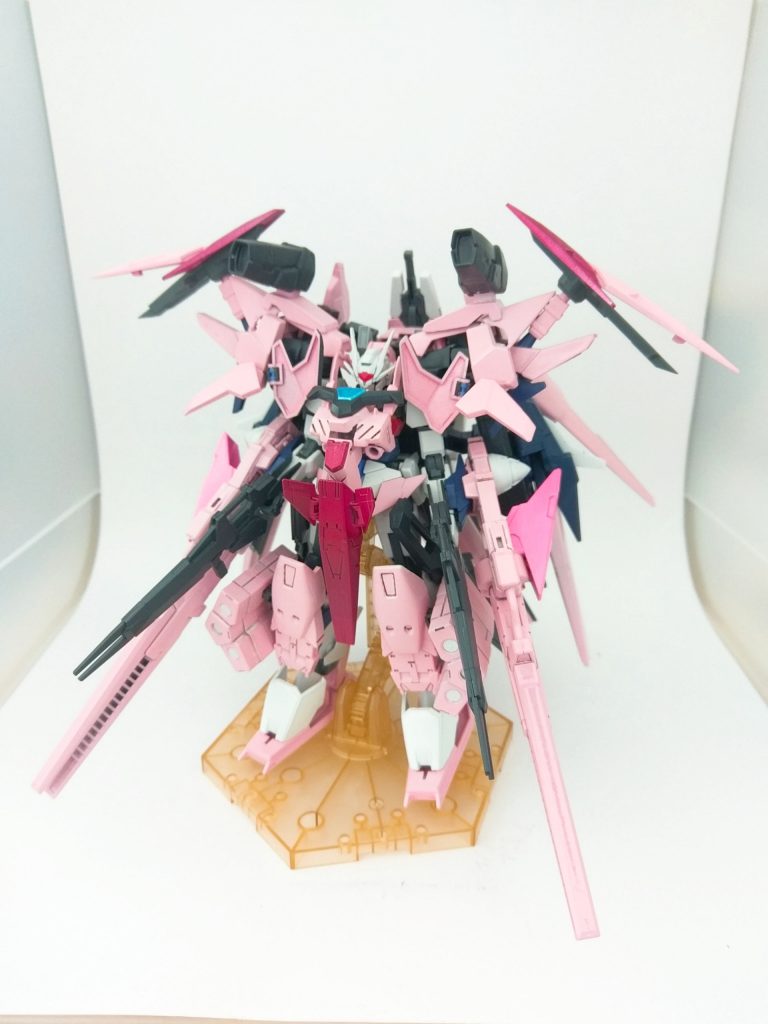 全身に装備を追加した形態「ダブルオーサクラ・ハルドレス」です。「フル」と「ハル」を掛けています。「フルアーマー」だとちょっと語感が微妙だったので「フルドレス」を採用しました。
全身にアーマーを追加することで完全に春っぽくほぼピンク色になりました。こうやって素のダブルオーサクラからハルドレスになっていくことで桜の満開に近付いていくように感じてもらえればうれしいです。
HWS(ヘヴィーウェポンシステム)のミサイルアーマーを中心に追加アーマーを作成しました。足にはミサイルを、腕には超長距離メガランチャー(ライトニングバックウェポン2のライフル)と更なる追加のGNドライブ(使い捨て)を追加してます。肩に被せるようにストライカージンクスのパーツをベースにアーマーを作成しました。胸はキマリスヴィダールの背面胸部アーマーとヴィダールの胸と腰パーツで追加アーマーを作成しました。胸の穴はキマリスヴィダールの背中ジョイントのやつです。足はインパルスのシールドを用いて大きな足にしてます笑