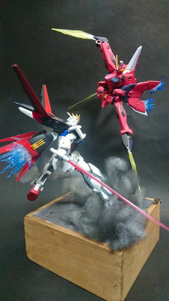 まずは全体図
上空から斬りかかるイージス、迎え撃つストライクの構図。
今回はバーニアの噴射エフェクトっぽいのとイージスのビームサーベルなんかも作ってみました。
余談ですけど今回ちょっと照明の調子悪くていつもより写真写りがいまいち…普段から良いとも言わないですが