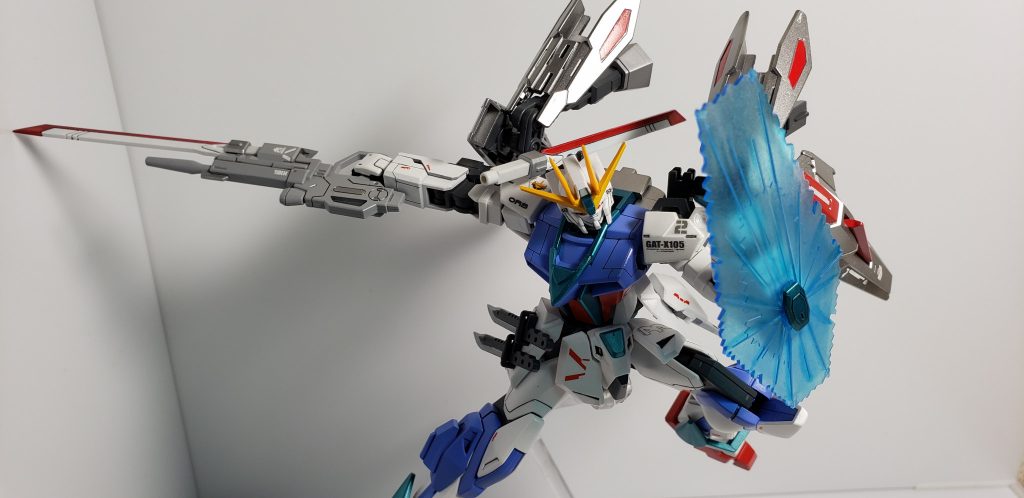 MX2200 ビームシールド 
左前腕部に装備されたビームシールド発生装置から発生する。 
ビームの出力を調整することで防御面を自在に変化させることができる。ストライクフリーダムと同様のものであるが、こちらは核エンジンを持たないため、一度の出撃でのエネルギーは有限のためむやみに使用できないという大きなハンデがあった。
 
ここは既存のストライクのシールドと迷いましたが、「強化版」というコンセプトを踏まえ、あったら強そうなビームシールドを採用しました。キットのままでは色が薄いと思ったのでクリアー色で濃くしました。