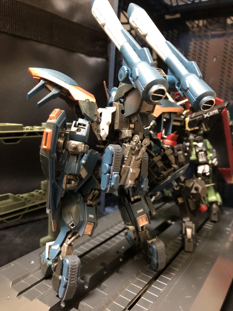 oyz「では機体解説だ。カラミティは初期GAT-Xの1機・GAT-X103 バスターの系譜に属する砲戦型MSで、トランスフェイズ装甲(TP装甲)の採用に伴う余剰電力の大半を火器に回したことで、バスター以上の攻撃力を実現している。視野の広い後方からの支援砲撃を主任務とする機体特性から、指揮官機としての機能も備えるのだ。」
オルガ「すっげーじゃんか！ハハハ！」
oyz「劇中初期ではビームをドカドカ撃ちすぎてエネルギー切れに陥り、クロトにバカにされることもしばしばであった。」
オルガ「うっせーよ。」
oyz「なお、バスターと同じく格闘武装はほとんど装備しておらず、接近戦は苦手とする。 重量級の機体だが各部の高出力スラスターにより高い機動性を備え、地表、水上をホバー移動することも可能である。レイダーより軽いっていう設定はなんなんだろう？」
オルガ「うるせー、知るかよ。」
oyz「こういった機体設定の為に長距離移動は難があり、劇中ではレイダーに載せて貰って途中で運搬されていた。まあ空中で落とさたりもしてたけどね。そこで今回の改造では、タンク形態に可変して機動力を改善した。」
オルガ「そこそこ使える、って事だな？」
oyz「ちなみにガズウートの可変から発想している。」
オルガ「その機体、SEEDの世界じゃ、めっちゃ雑魚じゃねえか！大丈夫なんだろうな、オイ！？」