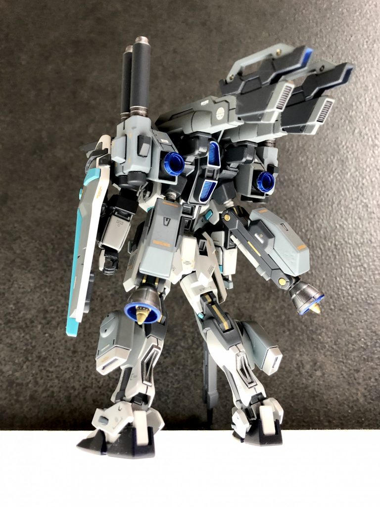 この機体は「初期生産型」に分類され、VPS装甲の最効率化を図るためのテストヘッドになっている。 コンセプトネームはリアガードで、後方支援の装備をメインとし、脚部には地上と水上をホバリングできるバーニアを装備している。また状況に戦術に応じて出撃前に武装を変更することができるストライカーパックを装備、その試験運用を前提とした機体調整が施されている。