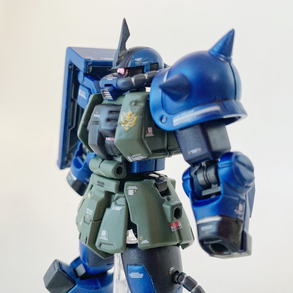 組み上げ途中の上半身【製作工程】①ゲート跡とパーティングラインを処理して、パーツ洗浄。②頭部アンテナ、左肩アーマーのスパイクを先鋭化。③タミヤ メイクアップ材シリーズ No.64 ファインサーフェイサー L (ライトグレイ) で下地塗装。④ラッカースプレー(タミヤスプレー TS-50 マイカブルー、TS-64 ダークマイカブルーほか)とエナメル塗料により全塗装。⑤ガンダムデカールNo.116 RG 1/144 MS-06R汎用1、ガンダムデカールNo.114 HG 1/144 機動戦士ガンダム サンダーボルト汎用1、ハイキューパーツ 1/144 RB01 コーションデカール ホワイト&オレンジを使用してマーキング。⑥GSIクレオス Mr.トップコート 水性プレミアムトップコート 半光沢 スプレーで仕上げ。⑦モノアイとビームライフルのスコープに、ダイソーのスワロフスキー社製クリスタルストーン(ライトローズ)を設置。