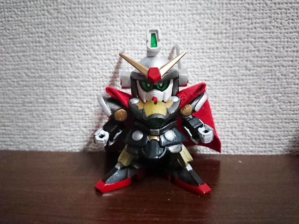 正面から
額のセンサーはレジン流し込んでクリアパーツ。目シールはSDCSクロスボーンガンダムから頂戴。胸部鎧と腰の衣装にある銀の円形はHアイズです。
両肩の金の円形部にはルーン文字のソーンを分割したものを彫り込んでます。
マントはフェルトを切って少しだけ裁縫したもの。胸部鎧によって固定されてます。