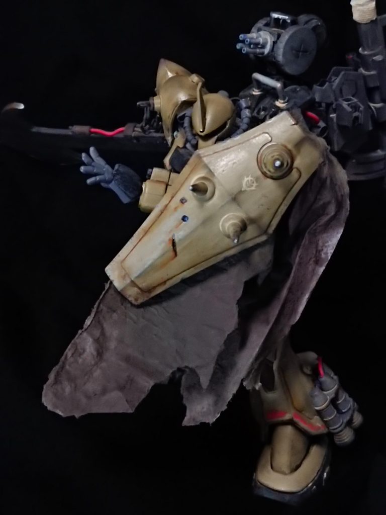 グフシールド
外部装甲として捉え、稼働軸を設けて左腕に装備。覗き穴は不必要となったため、スパイクを追加してタックル時の威力向上に役立てている。