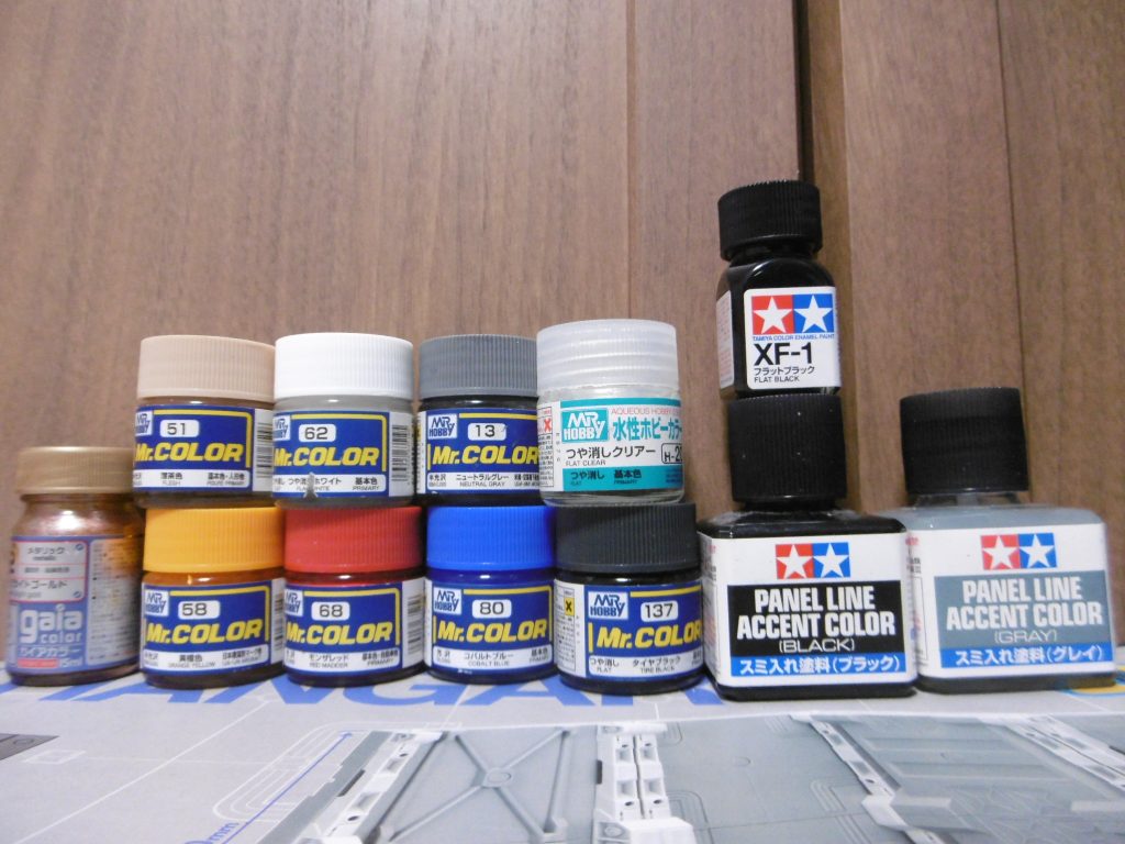 今回の塗料。エナメルはスミ入れ以外にも別の用途に。
ゴールドは腰のＶ字にのみ使っています。黄橙色では色を乗せ難いため。細か過ぎて筆では塗れず爪楊枝で。
赤以外は全体的に明るめに。最初は赤もモンザレッドではなくシャインレッドを予定していたのですが、気付かずに使っていました。意外としっくり来たのと、塗り直しがしんどくて現状維持。
ザクファントム足の成型色は黒なのですが、その成型色に強く影響されるため、一度白を塗って新たに下地色を作ってから赤を重ね塗りしています

ちなみに膝関節への塗装は、可動時に脚部動力パイプの動きに注意しないと塗膜をガリガリと削られます。撮影中に何度か再塗装のタイミングがありましたので、十分にお気を付けて