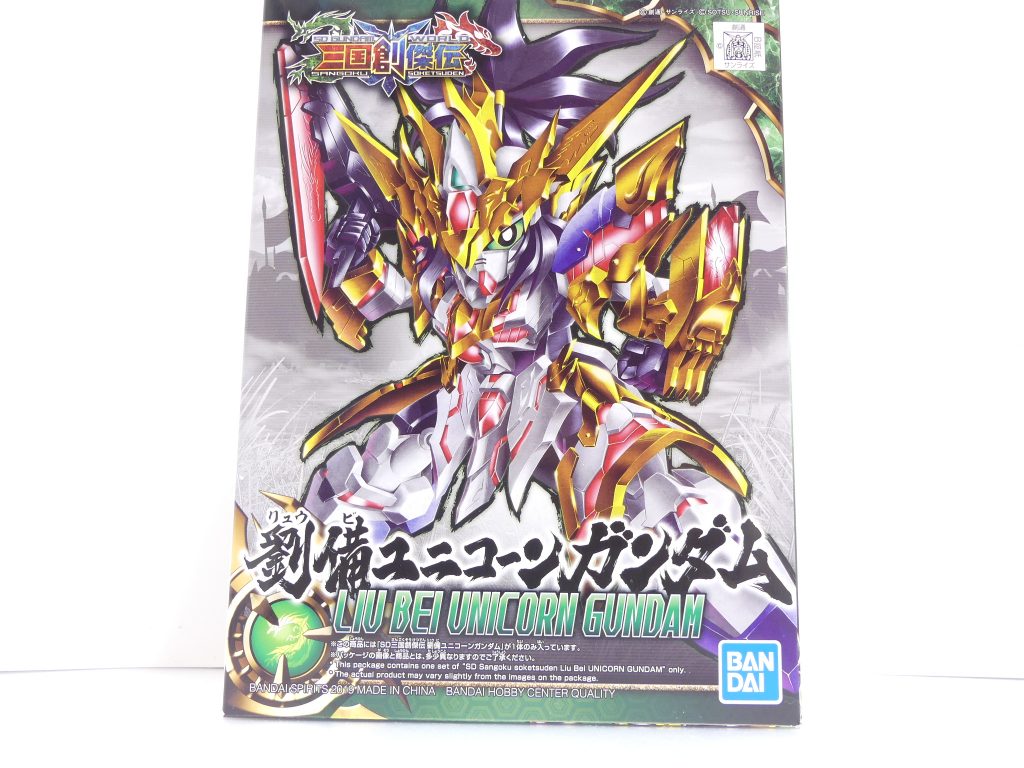 ブログの記事はこちら。
[世界観編](https://solphis2.blog.fc2.com/blog-entry-1080.html)
[劉備ユニコーン編](https://solphis2.blog.fc2.com/blog-entry-1081.html)

前回の「GBNW」の続きです。売り切れ前日になんとか確保できた劉備。
海外展開をメインとし日本ではガンダムベース限定特別販売の創傑伝。投稿時点（4/7）では既に売り切れており、個人的にも*「せめてガンダムベースポップアップあたりで売ってあげて」*と思う昨今ですが･･･

まず、本キットの成形・出荷が*中国*で行われていることは特記しておきます。それ故、今までの再入荷の流れは微妙に通用しません（もちろん再入荷予定はあり。次回は4月発売組と同じ4/27）。
パッケージ下の表記に注目。*「バンダイホビーセンターと同品質」*表記はあり、成型の精度などについては日本（今までのガンプラ）と変わりません。
ただし、説明書やシール台紙の材質などが微妙に違います。