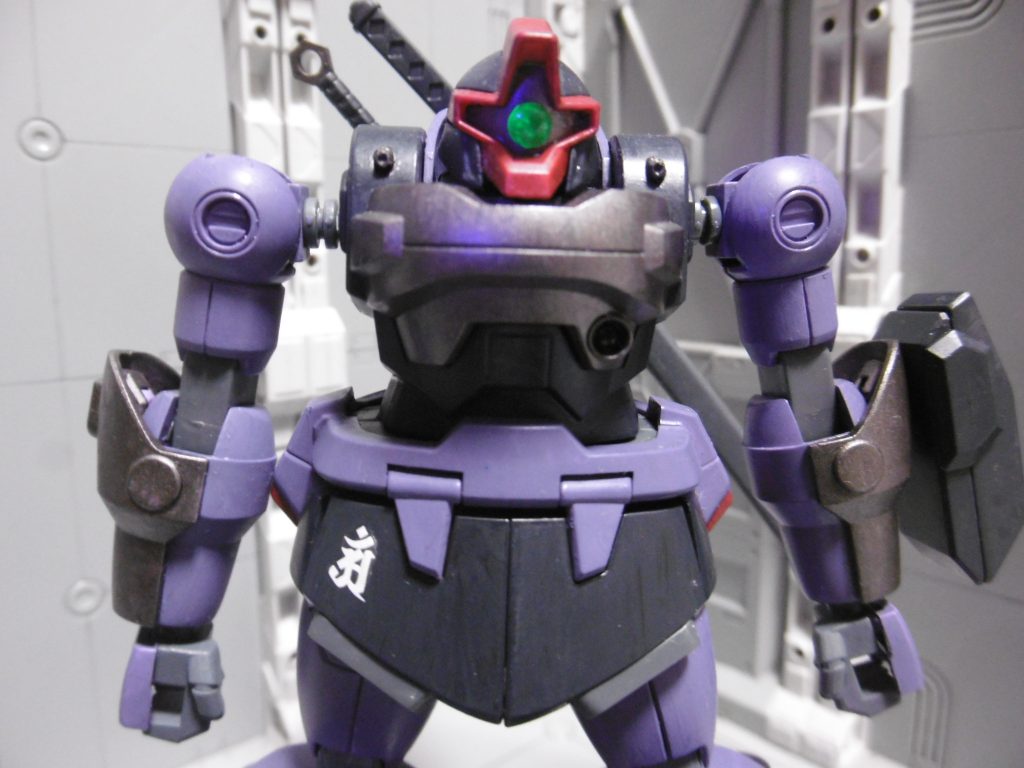 モノアイはH:アイズに変更。上からクリアーグリーン塗装。
ピンクではない理由は「赤系=警戒させる色」だから。
他のドム系と異なり頭を自由に動かせるので、モノアイ可動なし。下地は地味にしているため、ブラックライトを使わないと目立ちません。
(基本が好戦的な)ニンジャなら関係ないとは思うものの、忍びとしての括りである以上は慎ましくあってほしい
刀はこの構図だと本当は抜けません。しかし反対差しにするとキット上「腕が届かない」ので、敢えてこのような表現にしています。人間と同じ動きをメカにもさせるのは、無理がありますもんね。
苦無はラックに引っ掛けるだけ。固定はされませんが、角度によっては簡単にポロリしません。
ニンジャには定番とされる手裏剣は無し。対MS戦で効くようには思えませんし、かといって大型化させると細身による軽量メリットが薄れるので