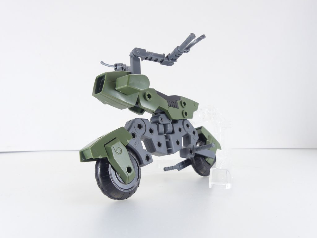 マシンライダー：ＧＢＮのダイバーがディメンジョン内の移動に使用するビークルの一つで、走破性に優れたバイクタイプのマシン。上記「ナデシコアスロン」で起こった事件により生み出された。※余談だが、２年後の世界ではきちんと一般のパーツとして存在しており、シドー・マサキのベッドには愛機・ガンダムテルティウムと共に安置されている（「リライズ」１３話）。テルティウムが乗れるかどうかはともかく、「バイク乗り」には好評だったようだ。１輪バイクはこれ以前にメテオホッパーがありましたが、ちゃんとした２輪バイクは初めてかな。後部のポリキャップに、専用パーツで向きを変えた台座の軸をセットして支えます。むしろ支えないと立ちません。左右と車輪カウル部分には大量の３ミリ穴が開いておりカスタマイズ可能。持ち手部分は自在に可動･角度変更可能。フロントカウルは３種、お好きなものを。中央のライト部分は全てクリアパーツです。