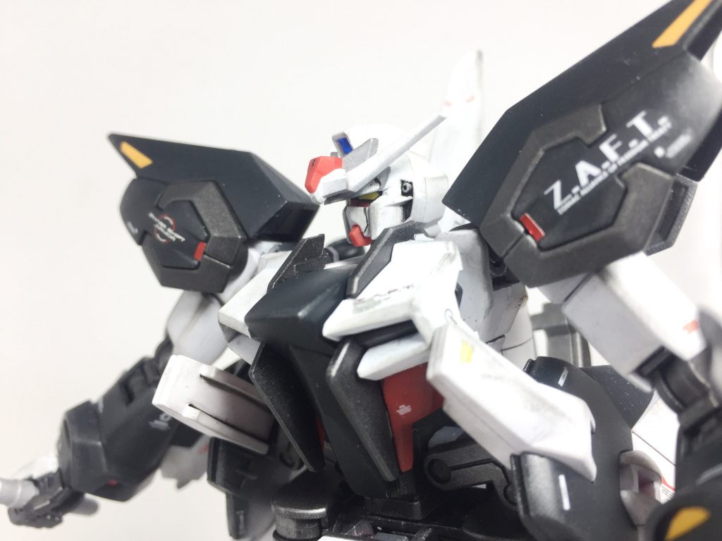 ~頭部~クルーゼの空間認識能力をより良く発揮出来るようにアンテナの一部を各種センサーを搭載したバイザーに変更されている。またストライク以外のG兵器頭部がスリット無しであった為、統一し口のスリットを閉口している。こうしてそれぞれの特徴をまとめたゼニスストライクであるがクルーゼの巧みなる操作技術がなければまともに動かせない非常にピーキーなMSと生まれ変わった。そんな中ザフト軍諜報部より連合軍が足つきと称される戦艦と共に地球に降り、新型MSを受け取るとの情報が入った。早速上層部より新型MSの奪取もしくは破壊の任を受けたクルーゼ隊は地球に降下する事となる。新型MSに乗るパイロットはあの男に間違いない…そう直感めいたクルーゼの考えは直ぐに確信へと変わった。*「やはり私の前に立ち塞がるのは貴様なのだな!ムウ・ラ・フラガ!」*対峙する「完璧」と「頂点」。その互角の力は長く長く…互いが相打ちで決着が付くまで続く事になる…