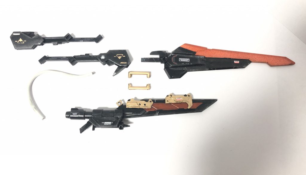こんな感じに分割できます
刃部分はセンチュリーウェポン
下の方の剣はスピニングブラスターから
柄の方は鉄血武器セット8のメイスをくっつけたもの(無改造できれいにはまります)
白いコードはiPhoneの断線したコード
下の剣に接着してある金色のパーツは食パンの袋を留めているアレを刻んで使用
真ん中の金色コの字パーツはランナーを加工したもの
これでパーツを留めてます
