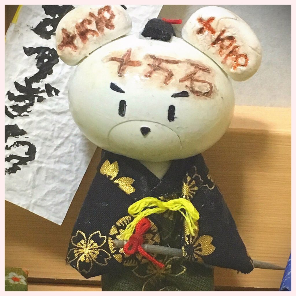 耳は紙粘土で作り、顔と耳は白のマニキュアで塗りました。
予め「十万石」の刻印になるように傷を付け、ブラウンのアイシャドウで焼き目を、刻印は茶色のペンで濃くしました。

写真では全然わかりませんが、一応ちゃんと袴を着た上に、黒い柄の羽織物を着ています。

頭のチョンマゲは、最後の最後にサムライ感が足りないな…と思い、そこで初めて気がついたので急遽こしらえました笑
黒フェルトを小さく丸め、細い紐でアクセントとなるように結わきました。

腰刀は爪楊枝。
こちらも水性ペンで塗り、チョンマゲと同じ紐で持ち手を結びました。