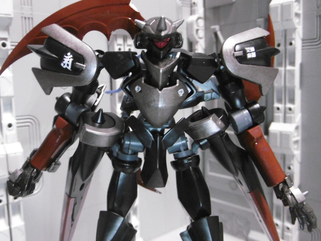 頭部をヒリング専用ガラッゾに変更。胴体側の肩アーマー正面を外し、前後逆に。背面は内部が露出し脆弱になりますが「ニンジャが背後を取られる事はあり得ない」ので問題なし。
腰はマスラオ式に変更。全体的にもマスラオ成分多めですが、塗装はスサノオで行いました。
戦闘用の忍装束を意識し、胸甲や肩などをメタリックカラーに。シルバーとブラックの中間である焼鉄色を使っています。この色は個人的に忍者表現でかなり使い易く、焼鉄表現に使う事は滅多にありません。
右肩に梵字【普賢菩薩】、左肩に【女神装置】の水転写デカール。
普賢菩薩は「智慧の象徴」「女性の救済を説く賢者」を意味し、機体名クシナダ(=女神)と合わせて「機体能力強化」の意味付け。メガミデバイスは一切使っていませんが「女神繋がり&MS≒装置」でもある事から、そのデカールを使いました。機体色に紅を入れているのもそのため。