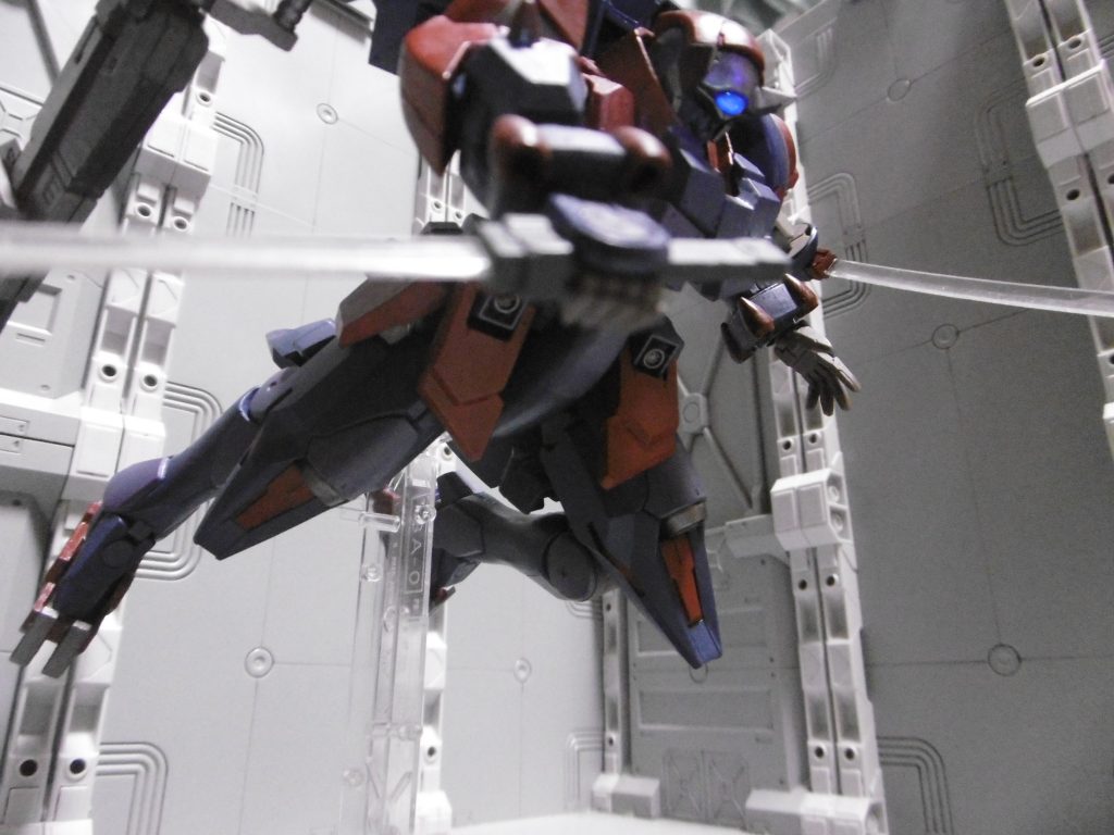 GN粒子の光学迷彩化により、ビーム発振も光学迷彩仕様。光探知を避けるだけでなく、不可視の刃で「何も無い所から斬り付けられた」と思わせます。グリップも小さく、近距離で無ければ分かり難いですし。
ビームサーベルではあるものの、上記の由来から不動明王の加護を受けており、強化GNステルスフィールドによるビーム兵器使用制限を受けません。
ブシドーアヘッドのGNビームサーベル使用。刀身は敢えて塗装せずクリアーのまま。今回は特殊格闘扱いではなく通常ビーム設定なので、従来のような蛍光クリアーによる塗装をしていません。