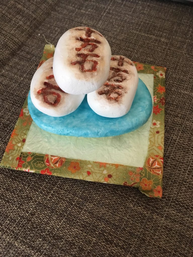 十万石饅頭サムライが神のように祀ったり、場合によっては食べてしまう超巨大十万石饅頭。
こちらも十万石饅頭自体は先程の小さいサイズと同様に、紙粘土で。
大きなお皿も紙粘土とマニキュア塗装。

下に敷いている台は納豆の蓋に千代紙を貼って、周りを布で貼りました。床の間風にしたくて、畳を目指した結果です笑