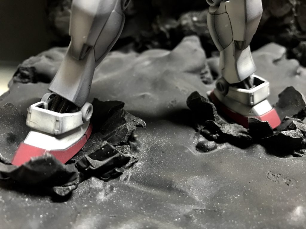 足元の表現はスプレー缶の蓋の内側にく窪みになるようにアルミホイルを被せて、石膏を薄く流し込み、固まって、割ったものをパテでくっつけて表現しています^_^ガンプラテクニックバイブルっていう本に書いた通りにすると出来た笑