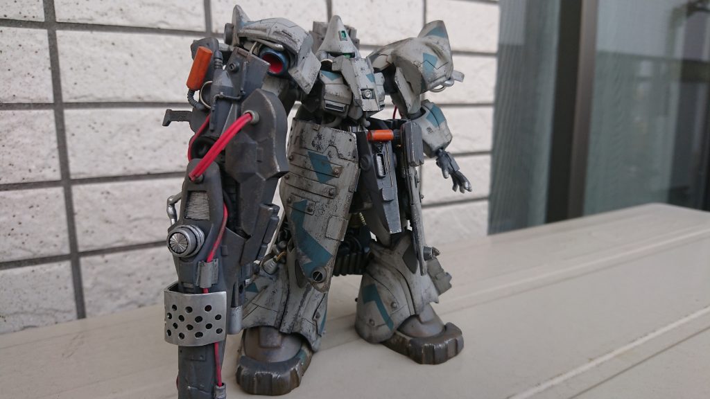 一年戦争後、小惑星アクシズにてゲルググの近代化改修案が提唱され、高出力の重攻撃機というコンセプトとして開発される。ほぼ全身に改修が施されており、原形は僅かに残る程度である。高いジェネレータ出力・直線推進力・反応速度を持ち総合的なスペックは最新鋭機を凌ぐポテンシャルを備えているとされるが、過剰な反応速度が与えるコックピットへの高Gや複雑な操縦系、癖の強い装備の数々、カスタムメイド然とした製造体制、加えて開発費の高騰から量産は不可とされ、近代化改修した主力機の座は「リゲルグ」に譲ることになる。しかし機体スペックは高いため少数がエース用として製造される。これらの特性からベテランパイロットによる操縦もしくはニュータイプ及び強化人間の搭乗を前提としたサイコミュによる操縦系の簡略・高精度化が不可欠とされる。本機は専属の強化人間パイロットと「エルメス」で実用化したサイコミュの簡略化モデルを備えており、機体駆動とコックピット操縦系に採用。地上用の処置を施した上で隕石に偽装したHLBにてアフリカの旧公国軍物資集積場に向けて投下。公国軍残党勢力の増援兼地上テスト機という位置付けとなった。