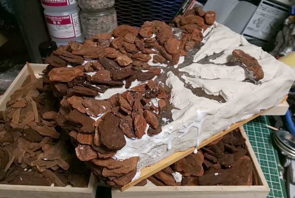 百均アクリルケースの上に
同じく粘土を盛り付け、
バークチップを中心から外へ破裂しているような流れで接着を重ねていきます。
ひびの部分に透明の液状ボンドを流し込みして最後、クリアイエロー、オレンジ、ブラッディレッドを吹き付け!