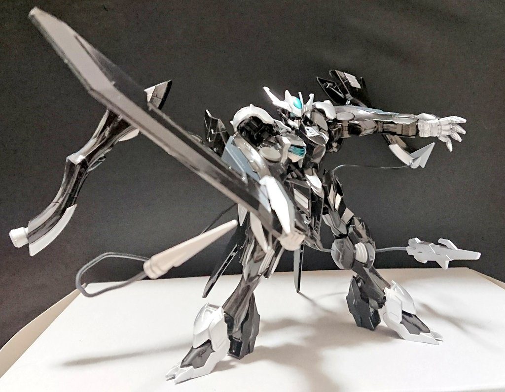 機体名：バルバトス・ハザード
別名：(バルバトス・ウルフハウンド)

[武装]グレートヒートソード、(大型)マガノシラホコ×２、メタルクロー改(アンカーネイル)、テイルブレード、となっている。

[総合スペック]1.0～13.0の内。
10.5～測定不能。

現時点で白兵戦最強の機体、他MSと比べても突出した機動力と防御力を誇る。
意思を持ったような目を持つ。

機体がうめき声のような音を出すと頭部、肩部、胸部から特殊な粒子が(微量)散布される、他のＭＳが粒子に接触しても何も効果は無いようだが。

兵装紹介↓
「グレートヒートソードは表面に熱を帯びさせる機能を持つ大剣だ(ON・OFFが可能)。

大型のマガノシラホコは対象を拘束するだけでなく周囲のもの(デブリや敵機)を薙ぎ払う事等にもよく使われる。

メタルクロー改は以前と違いネイル部分が追加された事でより鋭利になっている、並大抵のMSを装甲どころかフレームごと貫ける程の破壊力を持つ。
その為大剣が無くとも、いや無い方がより効率良く戦えるだろう。
(以前のメタルクローは敵機の装甲を抉る事は出来ても機体のフレームを直接破壊する事は容易では無かった)

テイルブレードはマガノシラホコと同様自由自在に操れる万能な武装だ 」

この機体は味方陣営の特殊なAIが操作しているガンプラなのだが学習を重ねた事によりもはや人並みの判断力を持つ。
凄い事なのだがその事を不安に思う者は敵味方問わず(少なからず)いるようだ。