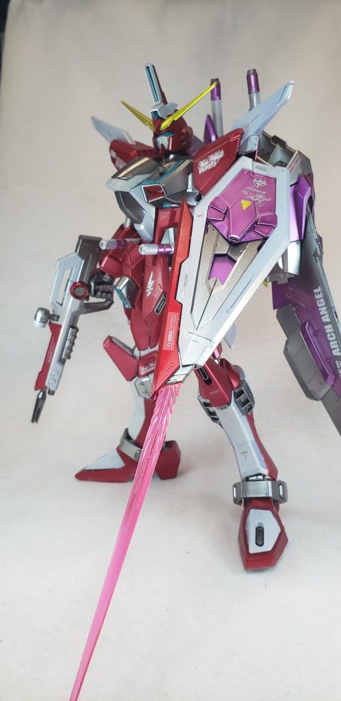 ポーズ３
MX-2002 ビームキャリーシールド
ビームシールドジェネレーター、ビームブーメラン、ワイヤーアンカーを内蔵する複合防盾兵装。そのため、シールドそのものは兵装のキャリアとしての意味合いが強い[43]。本機ではEEQ08とRQM55が装備されているが、マウント形状の変更により、他兵装も携行可能[52]。小説版では対ビームコーティングがなされた装備とされ、レクイエムの陽電子リフレクター突破に活用されている[53]。
    M1911ライフルと共に、ミーティア換装時はウェポンベイに格納される。