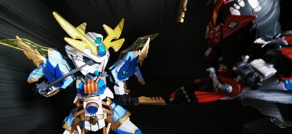 ◯武者俺崇帝守とのライバル関係-01
俺崇帝守の放つ蹴りが外異流の連理双牙に激突する。
刀と足の歪な鍔迫り合いが始まると鋼鉄のすり合う音が辺りに響く。
だが、その時は予想よりも呆気なく終わる。
「─なんだと!?」
外異流の持つ金の刀が鋭い音と共に弾けた。
勢いあまり地面に墜落した俺崇帝守は素早く上体を上げると刀が折れた事に驚愕する仇がいた。
「があああぁぁぁぁっ!あ゛あ゛あ゛あ゛あ゛──ッッ!!」
その叫びは恩師を貫いた刀を折った喜びと、殺しきれなかったことへの怒りが混ざった叫びだった。