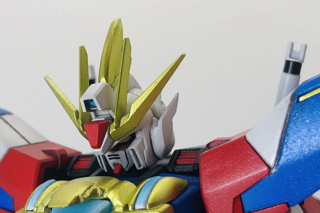 主役機を目指しただけあってカラーリングは結構派手。当初はマイ○ィ・ソーのような風貌を目指していたのですが、いつの間にか超サイ○人要素が加わり、このようなシルエットとなりました。頭部は、元となるビルドストライクの原形を可能な限り留めたくなかったので、頰のイーゲルシュテルンをオミットし、そこにプラ材を使用した装飾を追加、そのついでに小顔になるように顔周りを削ってます。額のカメラはRGストライクフリーダムのデカールを使用。