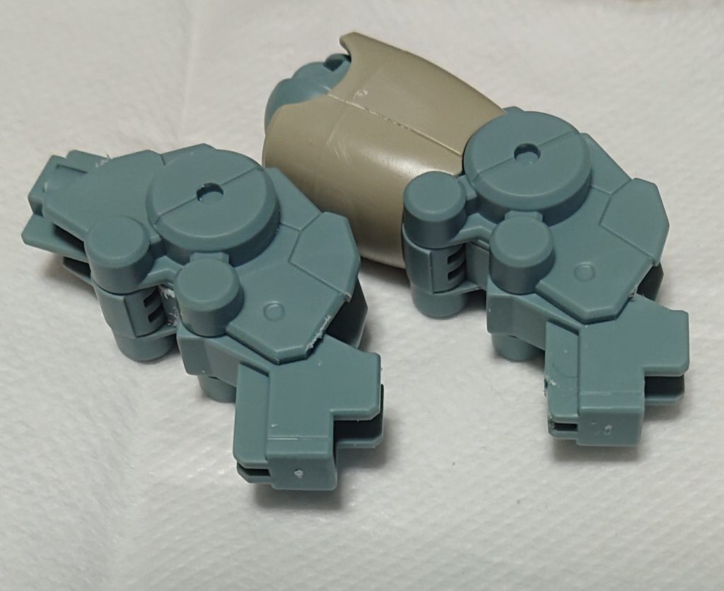 今回のミキシングのキモ。膝関節部分の加工。わかりにくいかもしれませんが、スネに差し込む側の突起の裏側をすこーーし削ってやることで、ジェガンのスネパーツ側のＰＣパーツを外すだけで差し込むことができます。
画像のように曲げた状態から差し込んでやると入りやすいかも。強度が心配な場合は塗装後接着してしまいましょう。（私は接着してません（ものぐさ）
ちょっとした加工で流用できるこの膝関節はちょっと可能性感じますね。