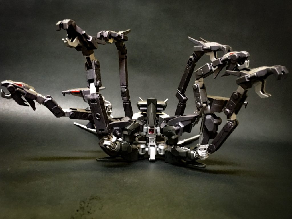 580mm複列位相エネルギー砲「スキュラ」
通常はアーム群に隠されている本機最大の射撃武装。
八機のバイパーアームによって捕縛、防御不可能の一撃にて敵を葬る戦法が強力