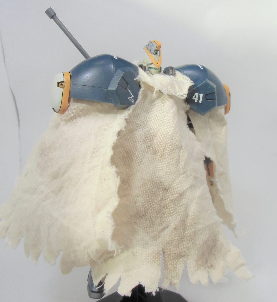 オプション装備として、EW版サンドロックが装備していた耐ビームコーティングマントを作成しました。
旧キット1/100ゲルググの肩をベースにボロ布を貼り付けて作成。