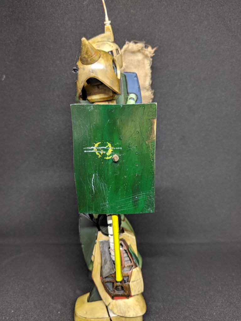 左側に残骸で作られたシールドと折れたドムのヒートサーベルを装備