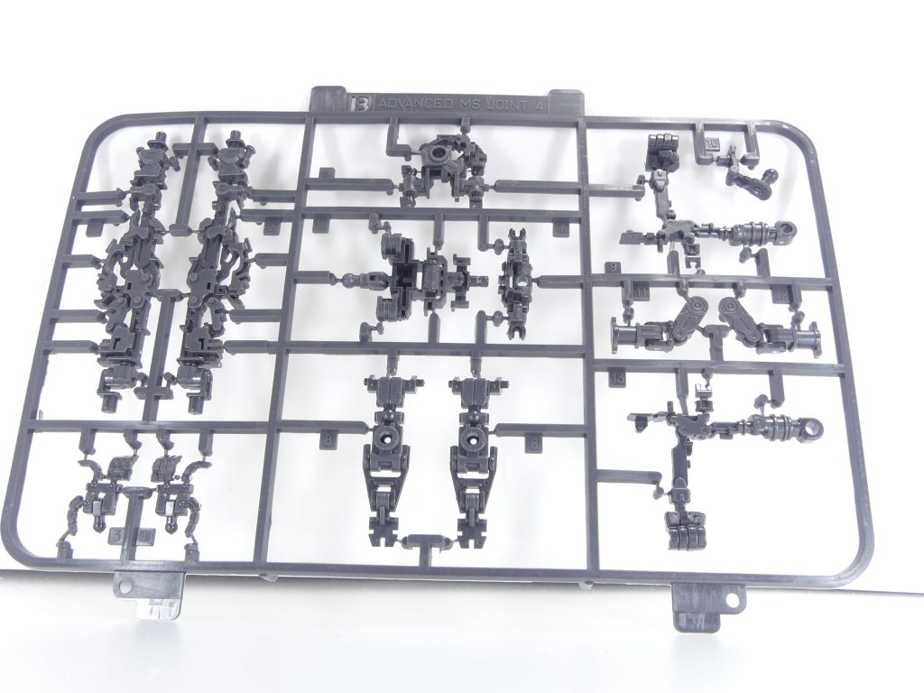 ロ「特に初期のＲＧを良くも悪くも象徴していたのが、この*アドヴァンスドＭＳジョイント*（以下ＡＭＳジョイント）。
ＡＢＳとＰＥの複合素材製内部フレームであり、ここから切り離す（+一部組み立て）だけで各関節・指の可動が出来てしまう･･･と言う、当時最高の技術であった。
なおこのジョイント自体は同型機のフリーダムと共用である（後編で生きるぞ）。

しかし、シリーズが進み、KPSなんてものがガンプラ界を席巻するとその弱点の方が目立つようになり･･･一言で言えば、*「素材の関係で大型MSなどには強度不足」*だった。
実際に組み立ててみると、昨今ガンプラに比べ関節がゆるいのだな。
そうでなくても多くのRGは翼など背中の背負いものが特徴となっており、各種スタンド（別売り）がなければまともに立てないものも多い。このジャスティスもそうであった･･･
最近のRG･･･先述のνガンダムなどは本ジョイントの出番を減らし（νではフィン・ファンネルの組み立てストレス低減に使用）ていると聞く。
一方で小型MSのクロスボーン・ガンダムではしっかり使ったり･･･適材適所な部分もある」