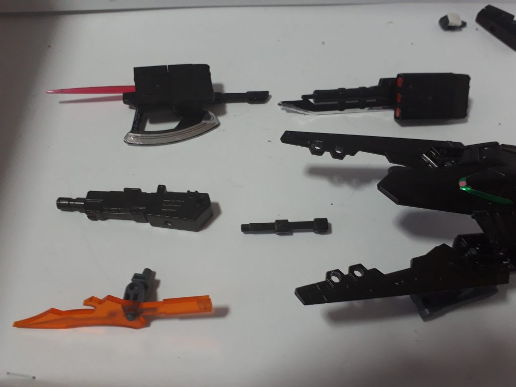 武装紹介1(外装武器)
*・万能兵装 GNアックスサーベル+GNミサイルシールド*
 ビーム・実体剣、ビーム・実体弾、4種類を一つで網羅した兵装。ミサイルシー 
 ルドは一応シールドとしても機能するため機体のコンセプトである究極の万能 にふさわしい兵装であるといえる。(ビームサーベルを接着しただけなので加 工コストも低い。)
*・準万能兵装 GNサーベルライフル+GNミサイルシールド*
 実体剣、ビーム・実体弾、3種類を一つにした兵装。ビームサーベルの機能はな 
 いが3つの兵装が同じ方向を向いているため一つ目に比べて扱いやすい。センサ 
 ーも付いているため射撃精度も一つ目のものより高い。
*・準万能兵装 ルーラレア*
 実体剣、ビームサーベル兼ビームガンの機能を持つ複合兵装。ただし四角の部 分がコンデンサーのため機体に接続していないとビームガンの弾数は数発、ビ ームサーベルも短時間しか使用できない。
*・GNクロー*
 ハードポイント化しているためあまり有効活用はできない。翼の役割も持つ。
・GN直列式ビームガン
 バトルアームズの台座取り付けパーツを二個繋げてロングバレル化をはかっ た。
*・大型NGNグレネードランチャー*
 しっぽ部分の兵装。