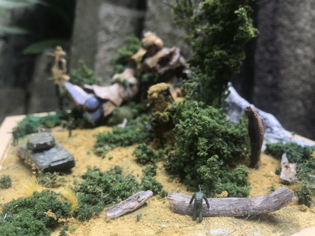 戦車の揺れに酔って倒木に寄っ掛かるグロッキーな自衛隊員。