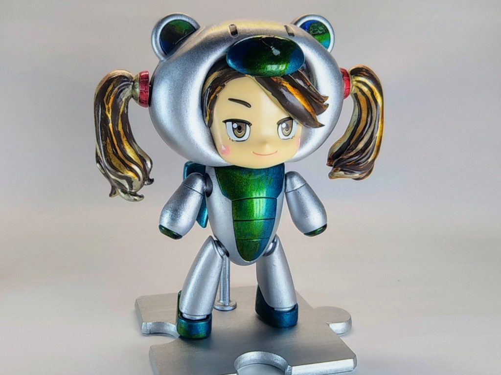 お次はギャン子。唯一、本体色はシルバー均一。ギャン子を塗装しているうちに、お菓子…特にチョコレートを連想してしまい、髪の毛はココアブラウンを基調としたブロンド仕上げに。お菓子というかマキアージュになってしまった…。グリーン部はゼロ戦の操縦席の定番色・青竹色（メタリックです）にクリアーグリーン。フミナとは異なるアプローチで表現しました。
