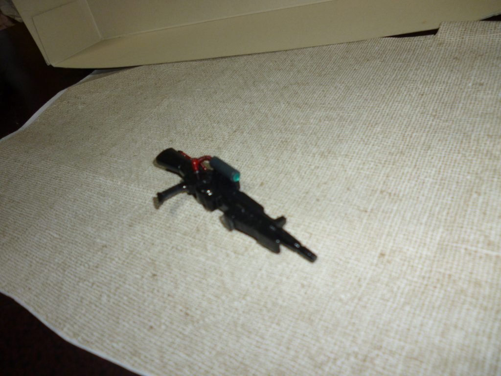 メイン武装のビームライフルです。
本来はバウ用の武装ですが、以前プレバンで購入したリバウの余剰パーツがあったので再利用しました。
スコープは、モノアイと同じくクリアパーツのランナーを切って差し込んであります。
実は、今回のR・ジャジャを「袖付き仕様」として製作したきっかけは、このビームライフルでした。
製作の構想を始めた当初、手元に銃剣付きビームライフルがなかったので、ネオ・ジオンの機体が装備していても違和感のない武装はないものかとジャンクパーツを漁っていたところ、丁度よさそうなものがこれだけだったのです。
しかし、本来バウ用の武装であるこのビームライフルを装備させる説得力のある理由が欲しくなり、「そうだ！若干旧式化してきた機体を『袖付き』が引っ張り出してきて、あり合わせの武器を装備させたことにしよう！！」と、後付け設定をでっち上げました（そのおかげで、あの地獄のエングレービング加工をするハメに・・・）。
ギャンのシールドを装備しているのも、あり合わせの武装でなんとか戦ってます感を強調するためです。