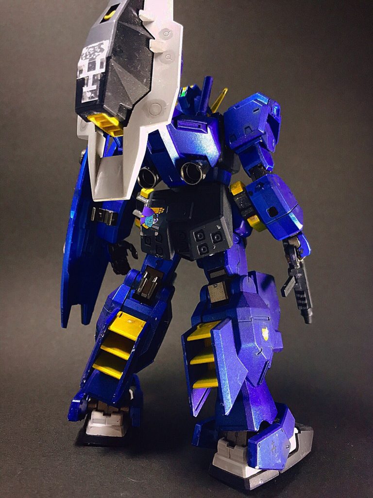 ポーズ1
一部を除き改修前と形状の変化は無いが、これまでの実動データおよび開発ノウハウからのフィードバックを受けて各パーツ間のマッチングが練り直され、実質上全くの別機体として生まれ変わっている。部材の再構成によって機体は改修前より軽量化され、約10%のスラスター出力強化によって総合的な機動性、運動性はさらに向上している。インターフェイス面も大幅に刷新され、コクピットには全天周モニター、リニアシートを本格的に導入。オペレーションシステムもバージョンアップが成され、操作性、反応速度共に格段に向上した。胸部コクピットブロックと腰部センターアーマーは、初代［ヘイズル］との数少ない外見的差異となっている。腰部センターアーマーは前方にスライドし、そこに様々なオプション兵装の評価試験のための多目的ラッチが増設される。