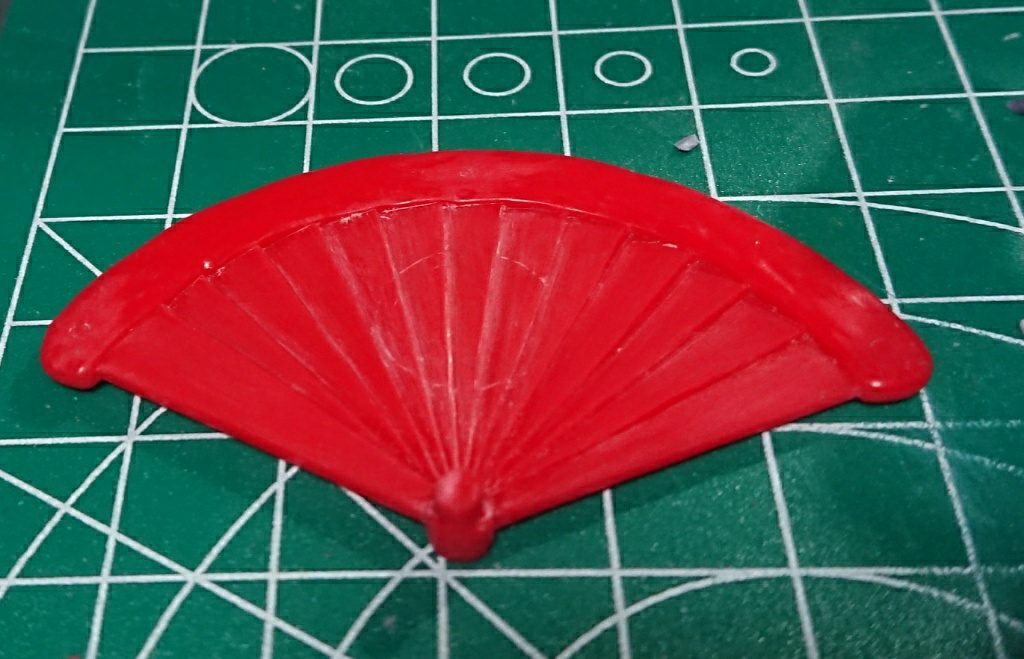 事の発端はセンスが殿様ガンダムのモノそっくりだと気づいたこと。しかし殿様ガンダムのセンスは中央がシールを貼りやすいように平面的に盛り上がっていたという…。頑張って削り落としました